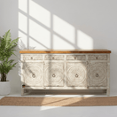 Switch Decorative wooden sideboard with carved patterns in a bright room with sunlight streaming through a window. 3 image